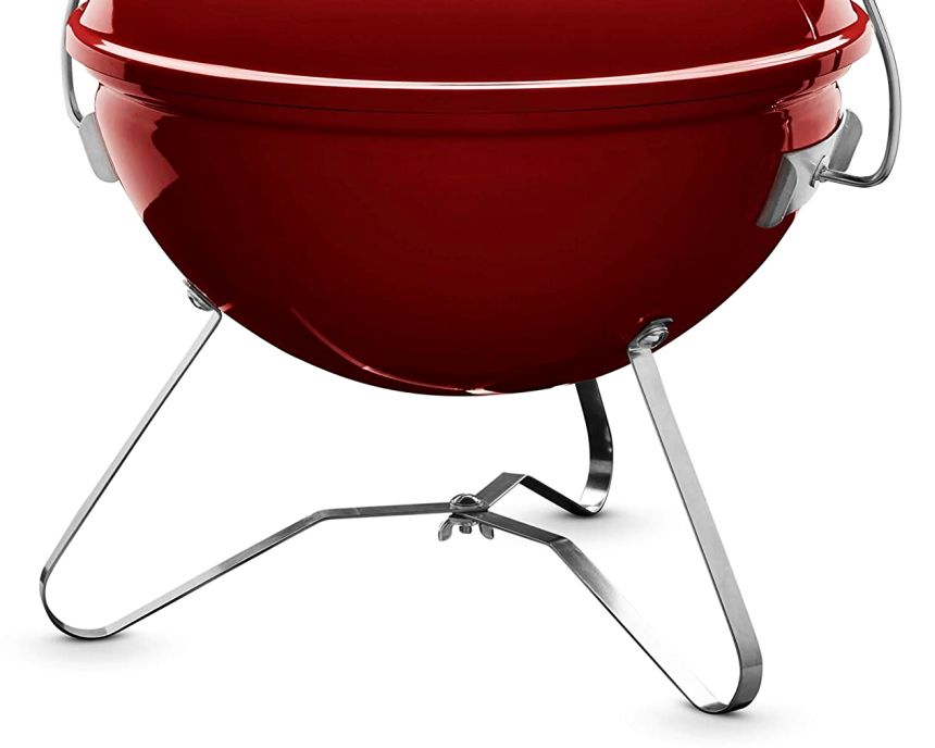 Il barbecue portatile a carbone WEBER Smockey Joe poggia su un semplice ma robusto treppiede in acciaio inox